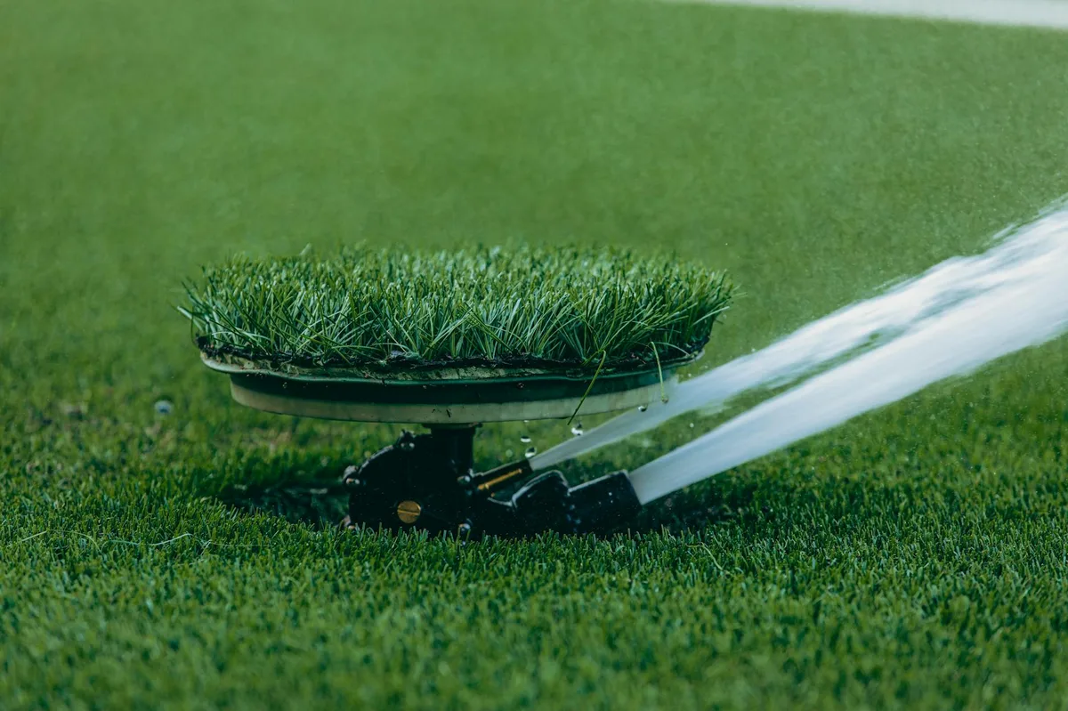 Sprinkler watering freshly laid sod in New Orleans backyard